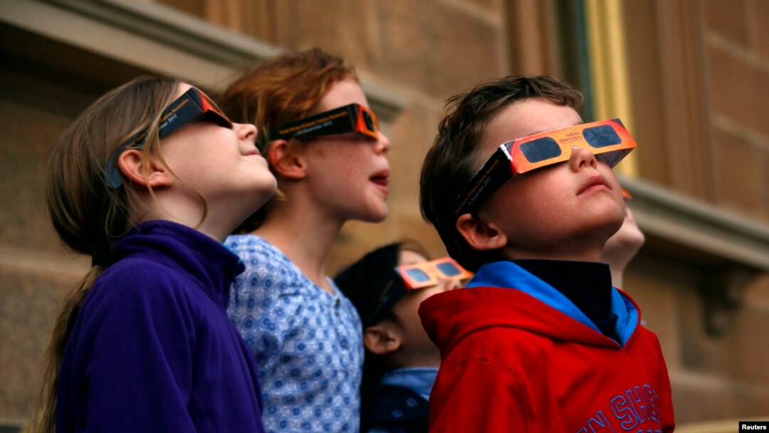 Anak-anak memakai kacamata pelindung untuk melihat gerhana matahari sebagian di Sydney's Observatory Hill, 29 April 2014. (Foto:dok)