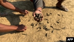 FILE - Residents hold bullet shells in a village in Rathedaung township, Rakhine state, Jan. 28, 2019, where fighting between the Myanmar military and ethnic Arakan Army (AA) took place from January 26 to 28.