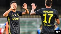 Pemain depan Juventus, Cristiano Ronaldo (kiri), bersama pemain depan Juventus asal Kroasia, Mario Mandzukic,merayakan kemenangan Juventus di akhir laga antara AC Chievo melawan Juventus di Stadion Marcantonio-Bentegodi, Verona, 18 Agustus 2018.