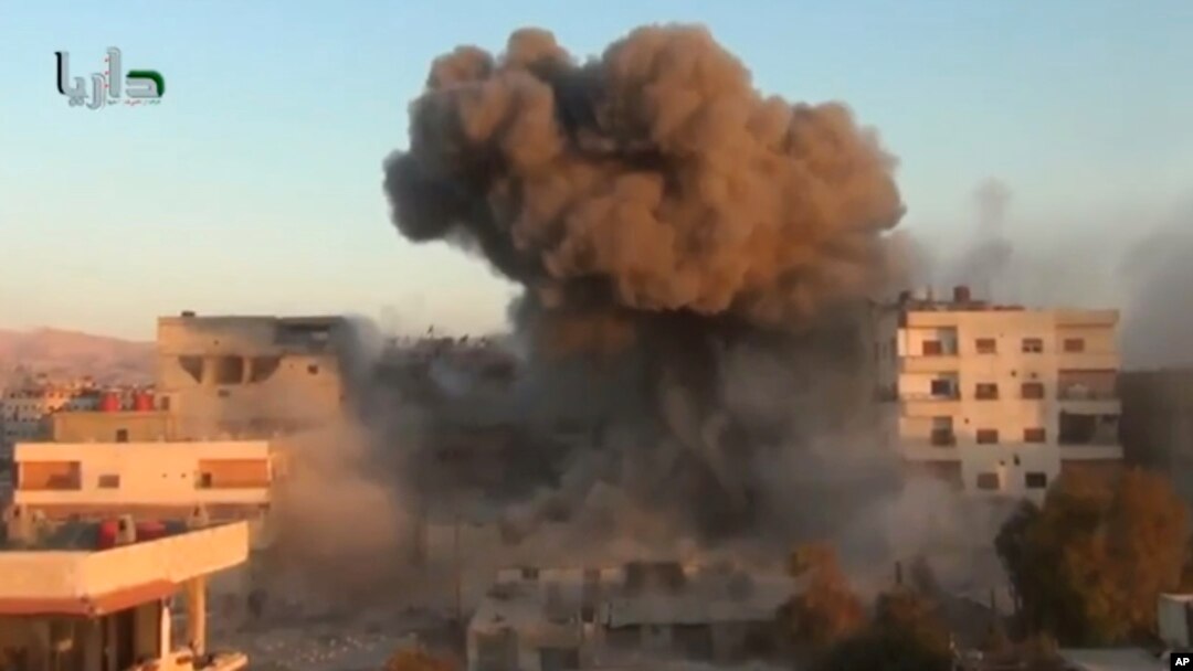 In this image taken from video obtained from the Shaam News Network, which has been authenticated based on its contents and other AP reporting, smoke billows amid buildings at a bomb explosion in Daraya, near Damascus, Oct. 15, 2013. 