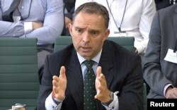 FILE - A still image taken from video shows Mark Sedwill, the top civil servant at Britain's Home Office at the time. giving evidence at a Commons Home Affairs Select Committee hearing in London, July 8, 2014.