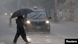 Un transeúnte con un paraguas camina bajo las fuertes lluvias provocadas por el tifón Shanshan en Miyazaki, suroeste de Japón, el 28 de agosto de 2024.