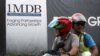 FILE - Motorcyclists pass a 1 Malaysia Development Berhad (1MDB) billboard at the Tun Razak Exchange development in Kuala Lumpur, Malaysia, Feb. 3, 2016. 