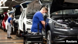 FILE - A worker toils on a Volkswagen assembly line in Wolfsburg, Germany, April 27, 2020. Investors and human rights activists are criticizing VW over claims made by the company's China chief that he saw no evidence of forced labor during a visit a VW plant in Xinjiang, China.