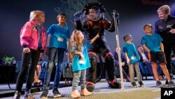 Axiom Space chief engineer Jim Stein, center, greets children during a demonstration, March 15, 2023, in Houston.