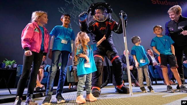 Axiom Space chief engineer Jim Stein, center, greets children during a demonstration, March 15, 2023, in Houston.