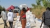 A displaced woman walks with a box of food on her head from a food distribution center at a U.N. compound in Juba, Dec. 23, 2013. (WFP)