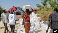 A displaced woman walks with a box of food on her head from a food distribution center at a U.N. compound in Juba, Dec. 23, 2013. (WFP)