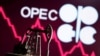 FILE - A 3D printed oil pump jack is seen in front of displayed stock graph and OPEC logo in this illustration picture.