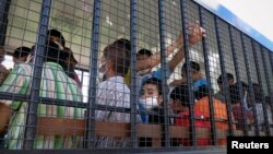 File - Suspected Uighurs are transported back to a detention facility in the town of Songkhla in southern Thailand after visiting women and children at a separate shelter.