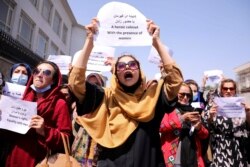 FILE - Afghan women's rights defenders and civil activists protest to call on the Taliban for the preservation of their achievements and education, in front of the presidential palace in Kabul, Afghanistan, Sept. 3, 2021.