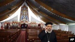 Father Girguis Lucas uses his cellphone before addressing reporters, inside the Coptic church Sainte Marie Saint Marc of Chatenay-Malabry, south of Paris, 04 Jan 2011.