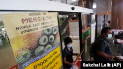 A sign raising awareness for the MERS virus is posted on a door at the building where a 75-year-old man is being quarantined for MERS (Middle East Respiratory Syndrome) along with three family members at the Bamrasnaradura Infectious Diseases Institute in Nonthaburi, Thailand, Friday, June 19, 2015. Thailand confirmed on Thursday its first known case of the deadly MERS virus, after killing a number of people in South Korea over recent weeks. Writing in Thai says, "If you have traveled from Saudi Arabia, United Arab Emirates, Qatar, Iran, or South Korea and have respiratory trouble please seek attention." (AP Photo/Sakchai Lalit)