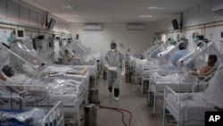 COVID-19 patients are treated inside a non-invasive ventilation system named the 'Vanessa Capsule' at the municipal field hospital Gilberto Novaes in Manaus, Brazil, Monday, May 18, 2020.