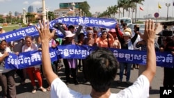 A leader, foreground, of Cambodian activists controls the group to pay respects in front of Royal Palace during a march toward the National Assembly, in Phnom Penh, file photo. 