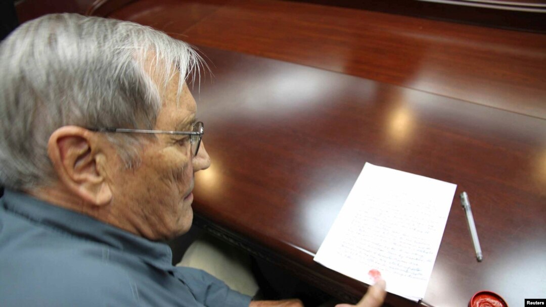Foto yang dirilis oleh Kantor Berita Resmi Korea Utara (KCNA), menunjukkan Merrill E. Newman, warga AS menorehkan cap jempolnya di sebuah kertas sesaat setelah ditangkap di Korea Utara (30/11).