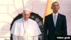 El presidente Barack Obama y el papa Francisco observan la ceremonia de recibimiento en el jardín sur de la Casa Blanca.