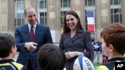 FILE - Britain's Prince William, Duke of Cambridge, and his wife Kate, Duchess of Cambridge meet young French rugby fans at the Trocadero square, in Paris, March 18, 2017.
