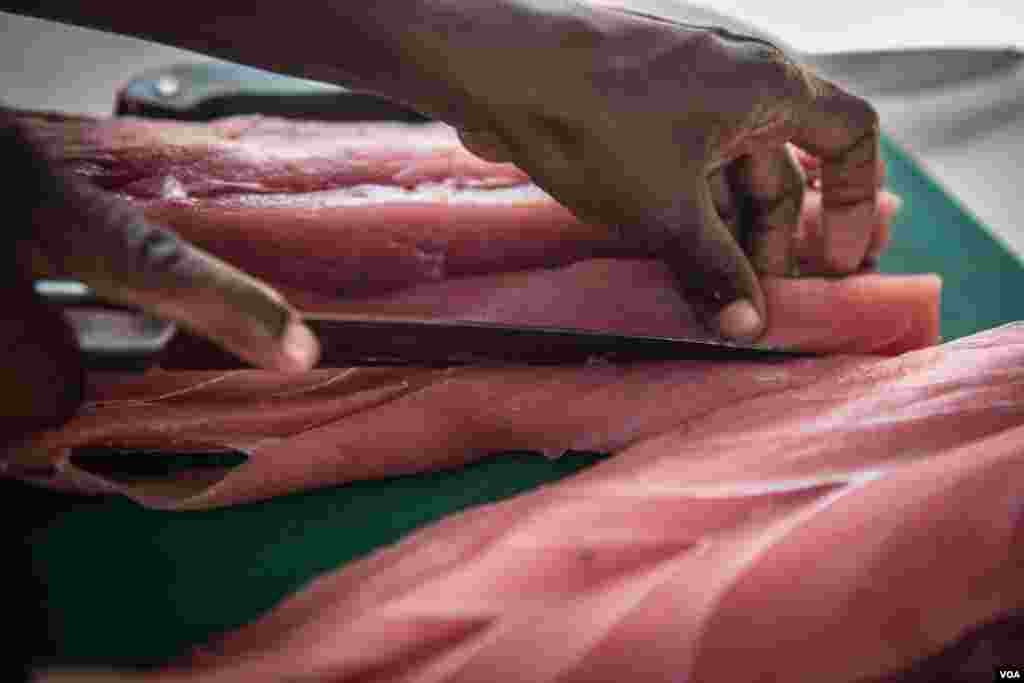 A woman slices up fresh fish to dry as part of a Food and Agriculture Organization program to boost Somalia's fishing industry. (J. Patinkin/VOA)