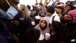 Para pencari suaka Amerika Tengah menerima pembagian makanan di Tijuana, Meksiko menunggu lamaran suaka mereka diproses dinas imigrasi AS (foto: dok). 