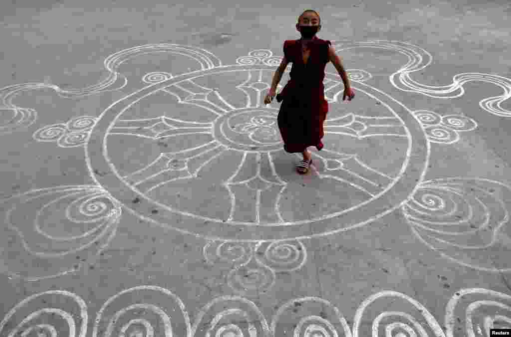 A novice monk wearing a protective mask runs at the premises of a monastery during the 18th day of the lockdown imposed by the government amid concerns about the spread of coronavirus disease outbreak, in Kathmandu, Nepal.
