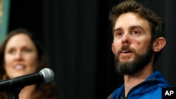 Travis Kauffman responds to questions during a news conference in Fort Collins, Colo., Feb. 14, 2019, about his encounter with a mountain lion while running a trail just west of Fort Collins last week. Kaufman's girlfriend, Annie Bierbower, looks on at left.