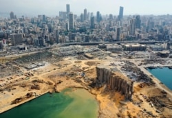 FILE - An aerial view taken on August 7, 2020, shows a partial view of the port of Beirut, the damaged grain silo and the crater caused by the colossal explosion three days earlier of a huge pile of ammonium nitrate.