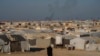 A woman walks in the al-Hol camp in northeastern Syria's Hasakeh province, where tens of thousands of mostly women and children linked to the Islamic State group have been living for years, Jan. 30, 2025. 