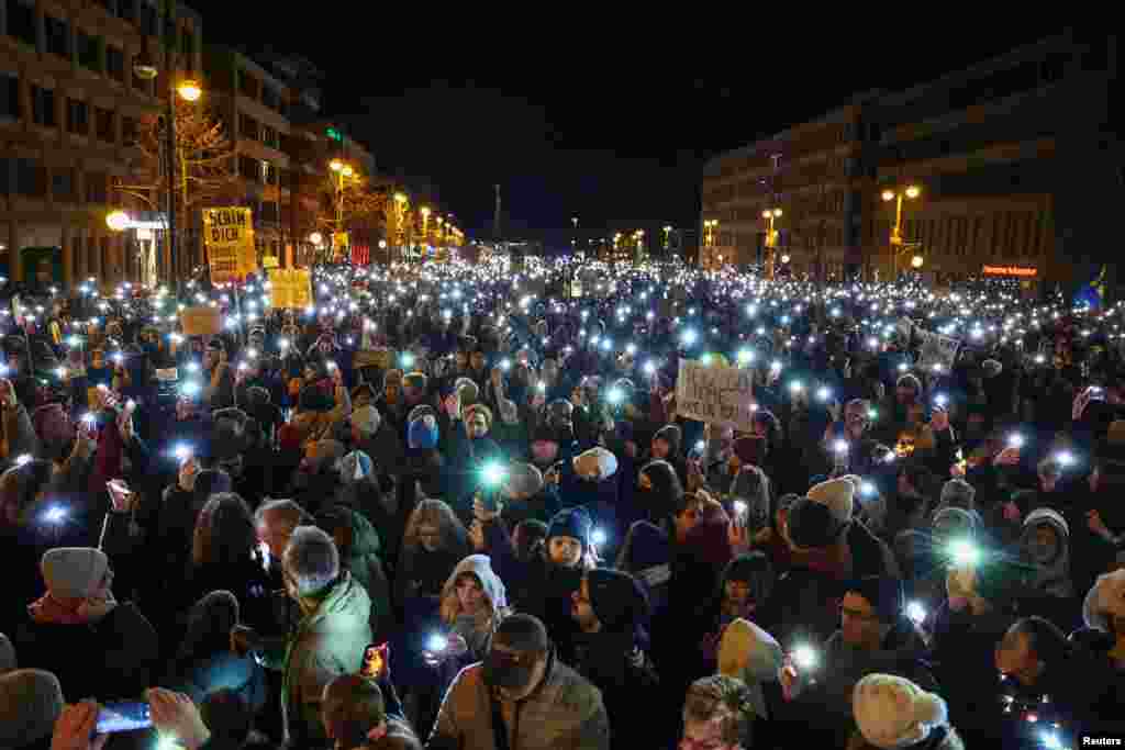 People light up their mobile phones during a protest against the migration plans of the CDU party leader and top candidate for Chancellor Friedrich Merz and the far-right Alternative for Germany party (AfD), in Berlin.&nbsp;