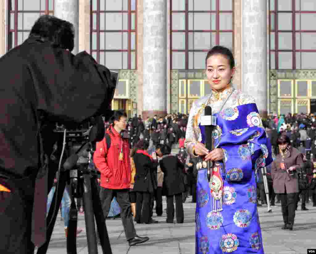 身着民族服装的西藏新闻记者在会场外进行报道。（2016年3月5日 美国之音金子莹拍摄）