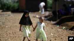 FILE - Young girls hold hands as they walk down a road in Marawi City, southern Philippines, June 15, 2018. A coronavirus lockdown in the region has brought a welcome reprieve in fighting between government forces and Muslim rebels seeking independence.