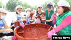 지난 9일 서울 양천구 양천공원에서 열린 전통고추장 담그기 체험행사에 참가한 새마을부녀회 및 다문화, 탈북 여성들이 직접 만든 고추장을 병에 옮겨 담고 있다.