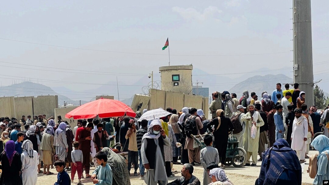 سەدان کەس لەبەردەم فڕۆکەخانەی نێودەوڵەتی حامید کارزایی لە کابوڵی پایتەختی ئەفغانستان کۆبوونەتەوە، سێشەممە 17 ی هەشتی 2021