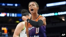 FILE - Phoenix Mercury guard Natasha Cloud (0) celebrates after making a shot while fouled during the first half of a WNBA basketball game against the Minnesota Lynx, May 31, 2024, in Minneapolis.