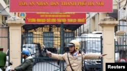 FILE - A policeman directs traffic in front of a court in Hanoi, Vietnam, Jan. 8, 2018. A court in the communist-run country's south reportedly sentenced two women Friday for anti-state propaganda.