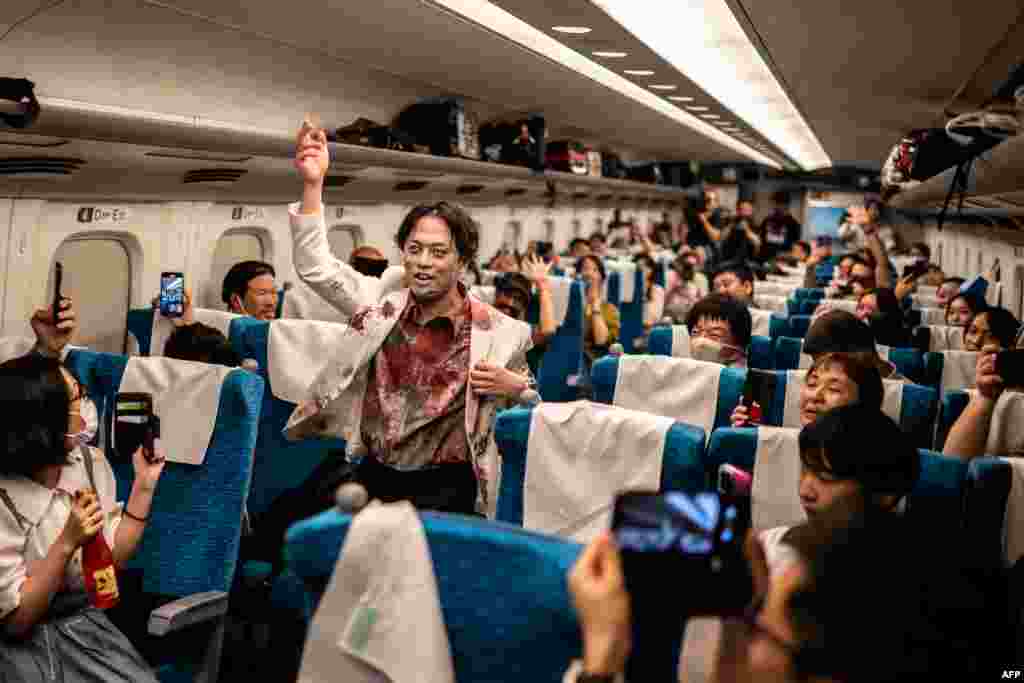 Passengers take pictures of a performer during the &#39;Zombie Shinkansen&#39; event on a bullet train from Tokyo to Osaka, Japan, ahead of Halloween, Oct. 19, 2024.