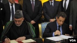 Presiden Perancis Nicolas Sarkozy (kanan) dan tamunya, Presiden Afghanistan Hamid Karzai menandatangani kesepakatan kerjasama dan persahabatan Perancis-Afghanistan setelah pembicaraan di istana Elysee, Paris (27/1).