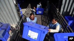 Afghan election workers load ballot boxes and other election materials on a truck for distribution at the Independent Election Commission compound, in Kabul, Afghanistan, Sept. 23, 2019. The election is Saturday.