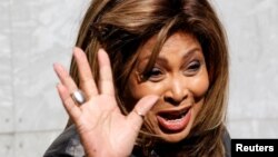 ARCHIVO - Tina Turner saluda durante una sesión de fotos en un evento de moda en la Semana de la Moda de Milán, en Italia, en febrero de 2011.