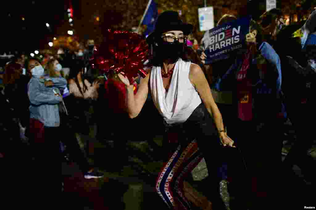 A woman dances after Democratic presidential candidate Joe Biden overtook President Donald Trump in the Pennsylvania general election vote count, in Philadelphia, Pennsylvania, Nov. 6, 2020.