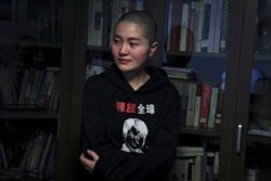 FILE - Li Wenzu, wife of prominent Chinese human rights lawyer Wang Quanzhang wears a sweater with her husband's portrait printed with the words "Release Quanzhang" after Wang's sentencing, at her house in Beijing, Jan. 28, 2019.