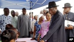 Nigerian incumbent President Goodluck Jonathan, second right, registers to vote in Otuoke, Nigeria, Saturday, April 16, 2011