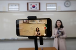 Teacher Chung Ha-eun gives an online class amid the new coronavirus outbreak at Seoul girls' high school in Seoul, Thursday, April 9, 2020. Senior high school students begin school semester with online classes.