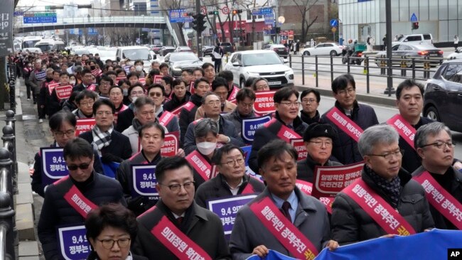 Doctors march toward the presidential office during a rally against the government's medical policy in Seoul, South Korea, Feb. 25, 2024.