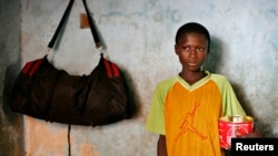 FILE - Harouna Ba, 11, a Talibe, or Islamic student, holds a begging bowl at a Dara, or Koranic school, in Pikine on the outskirts of Senegal's capital Dakar.