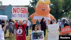 Para demonstran melakukan unjuk rasa menjelang kunjungan Presiden AS Donald Trump di lokasi penembakan massal di kota Dayton, Ohio, Rabu (7/8). 