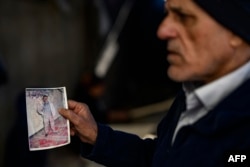 Mehmet Erturk, a Turk imprisoned in a Syrian prison, shows pictures during an interview with AFP journalists at his house in the village of Magaracik in Kilis on Dec. 13, 2024.