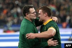 FILE - South Africa's coach Rassies Erasmus (L) embraces South Africa's flanker Jasper Wiese (R) during the France 2023 Rugby World Cup Final match between New Zealand and South Africa at the Stade de France in Saint-Denis, on the outskirts of Paris, on October 28, 2023.