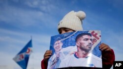 Una joven sostiene una foto de Suárez en Montevideo el 31 de julio de 2022. A sus 37 años, el jugador acumula un total de 142 encuentros disputados con la Celeste, en los que anotó 69 goles y brindó 39 asistencias.