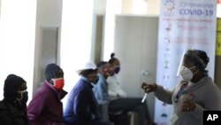 Un agent de la santé converse avec des volontaires pour le test d'un vaccin anti-COVID-19, à l'hôpital Chris Hani Baragwanath de Soweto, à Johannesburg, le 24 juin 2020. (AP Photo)